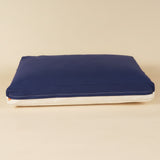 Back view of a premium kapok dog bed in navy and white
